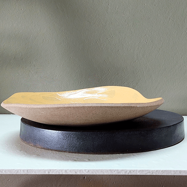 Centro de mesa cerâmica Açafrão elaborado em argila capuccino com esmalte preto fosco e amarelo brilho.
