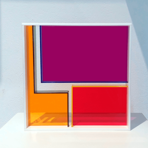 Escultura Módulo de acrílico série Android #14. Elaborado em acrílico translúcido roxo, laranja, amarelo, vermelho, azul e verde. Moldura branca.